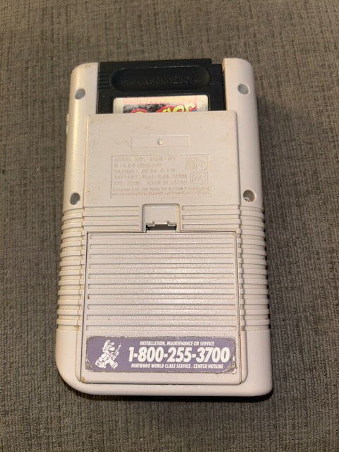 Classic gray Nintendo Game Boy powered on displaying Frogger