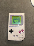 Rear of classic gray Nintendo Game Boy Unit B with battery cover in place