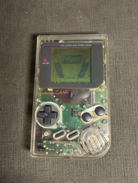 Clear-shell Nintendo Game Boy powered on with visible internal circuitry