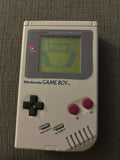 Front of classic gray Nintendo Game Boy Unit D displaying Frogger